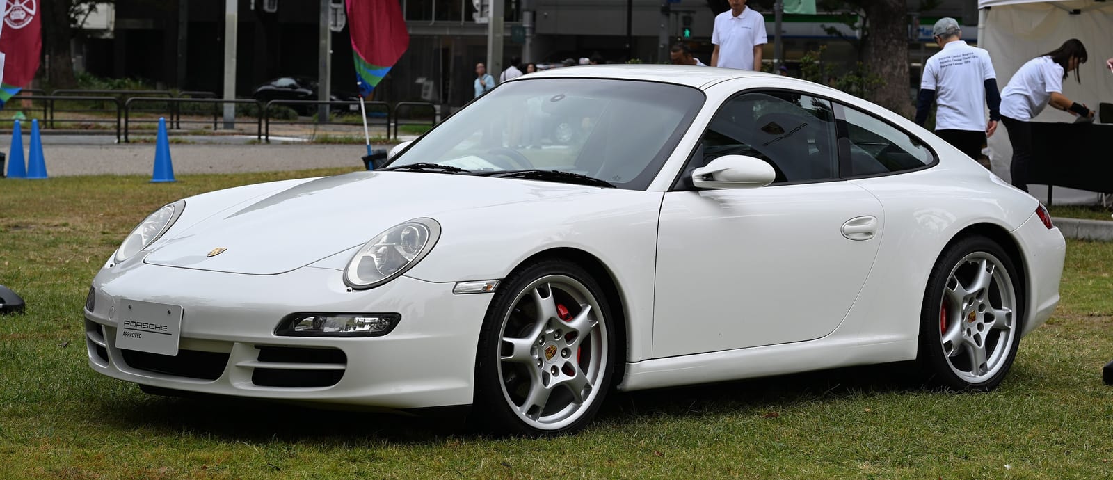 White 2007 Porsche 911 Carrera S (997.1) coupe on grass at an outdoor car event, front three-quarter view